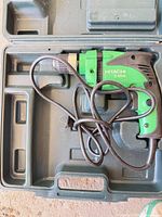 Green Hitachi D10VH drill with power cord inside molded case