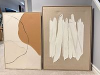 Both abstract paintings side by side to show size, frames and design contrast