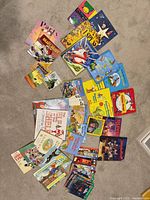 Entire assortment of approximately 30 children’s books laid out on carpet