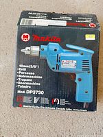 Retail box showing Makita DP3730 drill and specifications