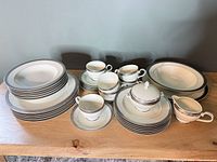 Full set showing stacked dinnerware, cups, sugar bowl, creamer, serving pieces