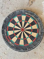 Close view of Nodor dartboard front, showing branding and wear