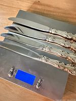 Four Gorham dinner knives on a scale showing total weight