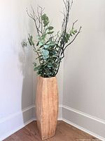 Full view of wood floor vase with faux eucalyptus and branches