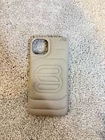Front exterior of taupe padded case with quilted design and camera cut-out