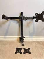 Full view of dual monitor arm assembled with central pole, clamp, two arms, two plates installed