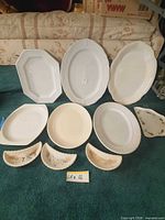 Group shot of ten serving pieces arranged on floor
