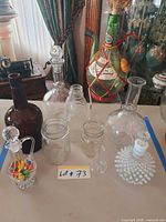 Group shot of all glass bottles and decanters displaying variety and stoppers
