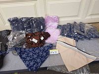 Assorted packaged and unpackaged bandana face mask scarves in multiple colours and patterns displayed on surface