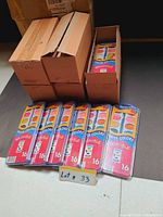 Unopened watercolor packs stacked beside open shipping boxes