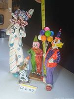 group view of all four clown figures with tape measure for scale