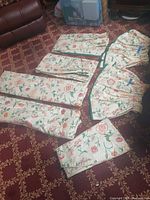 All folded textile pieces laid out on patterned carpet