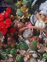 Box containing variety of glittered fruit picks, artificial flowers, greenery and small angel