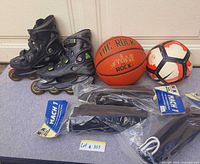 Group shot of inline skates, basketball, soccer ball and three sealed shin-guard packs