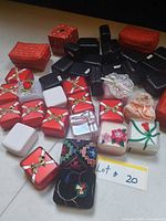 Array of red, white, black, embroidered and plastic jewelry boxes laid out