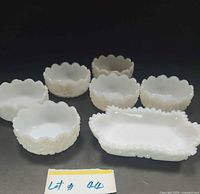 All seven milk glass pieces arranged showing shapes and scalloped edges