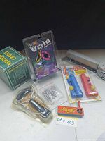 All items arranged: Newton’s Cradle box, Void Puzzle, slingshot, steel balls, pop-guns, KI truck