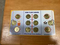 Front view of display board holding twelve gold-tone medallions