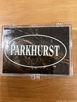 Clear plastic snap-case with Parkhurst logo containing card set