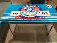 Full view of beach towel laid flat showing logo, text and condition