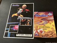 Poster and front of sealed Shreddies cereal box side by side