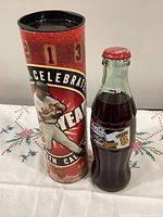Bottle and display tube standing side by side showing graphics and full sealed contents