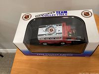 Boxed 1:24 scale Carolina Hurricanes Zamboni coin bank, front view with clear window showing model