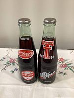 Front of both sealed Dr Pepper commemorative bottles