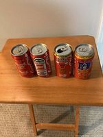 Four commemorative Coca-Cola cans in one group shot