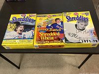Front view of three Wayne Gretzky Post Shreddies promotional cereal boxes, tops opened, no contents