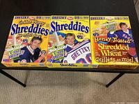 Front view of three Wayne Gretzky Shreddies cereal boxes on table