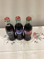 Front view of three sealed 8oz Coca-Cola NFL commemorative bottles showing labels and caps