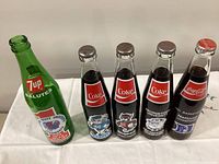 Front view of five commemorative soda bottles
