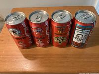 Front view of four red Coca-Cola NFL commemorative cans standing side by side