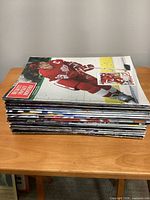 Stack of magazines, top issue shows Detroit Red Wings player in red uniform