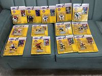 Thirteen sealed 1995 NHL Starting Lineup figures arranged on sofa