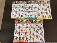 Five sealed Topps NHL Hockey Sticker sheets laid out