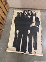 Full view of damaged Beatles poster on floor