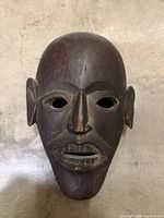 Front view of carved wooden mask showing facial features
