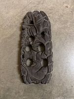 front view displaying carved bird and foliage with five oval piercings