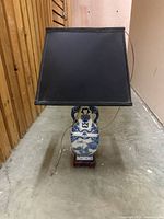 Front view of blue-and-white porcelain lamp on wood base with black shade