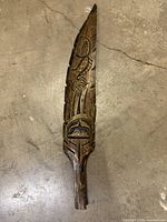 Front view showing full carved feather and motifs