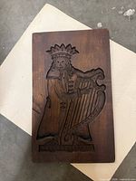 Front view of carved wood plaque showing entire relief image