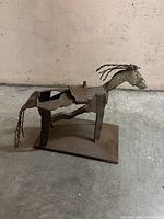 Front/side view of welded metal horse sculpture on rectangular base
