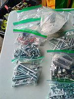 Assorted bags of bolts, screws and washers on table