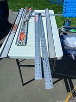 Overall view of two T-squares, two straight edges and clamp parts on table