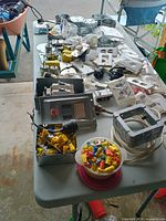 Overall view of table with breaker box, wire nuts, junction box, wall plates and fittings