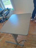 Desk top and single central leg with T foot