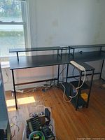 Left section of desk under window with monitor shelf visible
