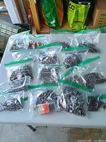 Top view showing multiple zipper bags of assorted nails and fasteners on table